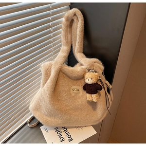 Detail van de pluche beige schoudertas met S-patch en schattige bruine beer hanger