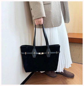 Detail of the black suede tote bag with leather straps and golden metal buckle decoration