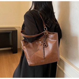 Detailansicht der braunen Leder-Shopper-Tasche mit Knotendetail und Logo-Druck