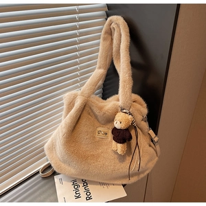 Gedetailleerde opname van een beige pluche handtas met een schattige teddybeer hanger