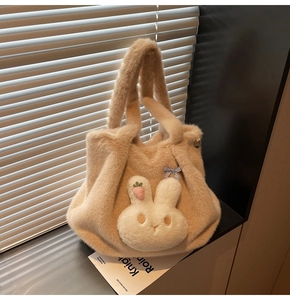Detail of plush beige tote bag featuring a cute 3D bunny head with bow and carrot embroidery