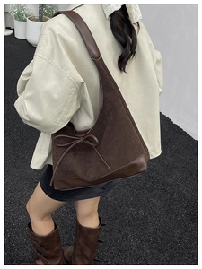 Detailed view of coffee brown tote bag with suede texture and leather bow tie