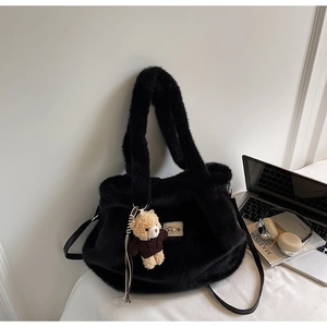 Detail van zwarte faux fur handtas met parel patch, beertje hanger en lederen riem