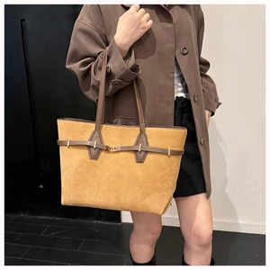 Detailed view of ginger suede tote bag featuring dark brown leather straps and gold buckle