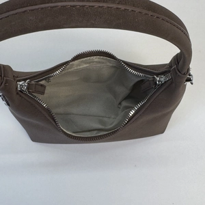 Top macro view of brown suede dumpling bag showing silver zipper and chevron lining