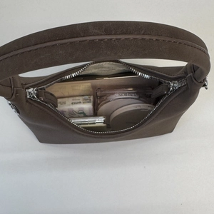 Top-down view of a brown suede croissant bag showing spacious interior with daily items