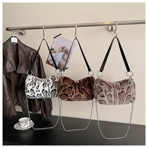 Close-up of fluffy leopard print handbags with chain straps and faux fur texture
