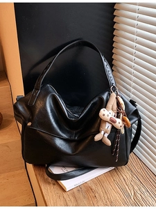 Vintage large capacity black tote bag with cute rabbit pendant on a wooden surface