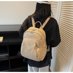 Detail view of beige lychee leather backpack showing large capacity on model