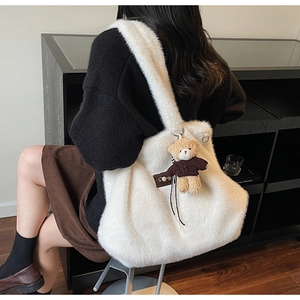 Gedetailleerd zijaanzicht van witte pluche draagtas met beer-hanger voor herfstmode