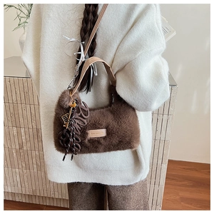 Detailsicht der braunen Plüschhandtasche mit Anhänger und weicher Kunstpelztextur