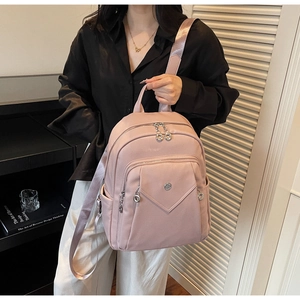Detail of pink faux leather backpack featuring pebbled texture and multiple zipper pockets