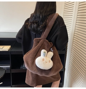Close-up of fluffy brown tote bag with cute white rabbit plush charm and soft shoulder strap