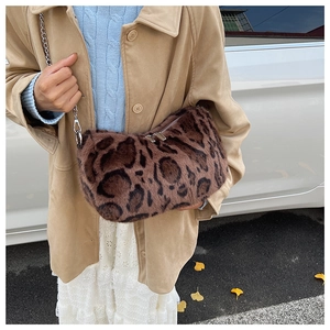 Detail of plush leopard print shoulder bag with silver chain strap and metal dual zippers