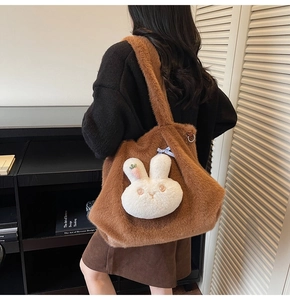 Close-up of a brown plush tote bag with a cute 3D bunny head and carrot detail