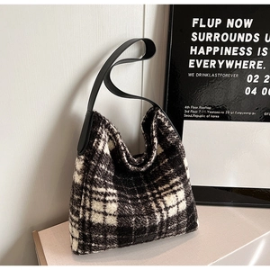 Detail of black and white checkered wool tote with premium leather shoulder strap