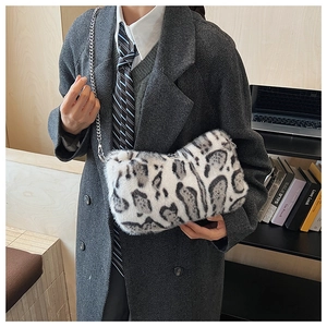 Detail of faux fur leopard print bag featuring a plush texture and silver metal chain strap