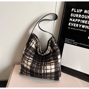 Detail of classic black and white houndstooth hobo bag with sleek leather shoulder strap