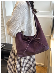 Detail of dark purple suede hobo bag with a leather bow and smooth leather trim