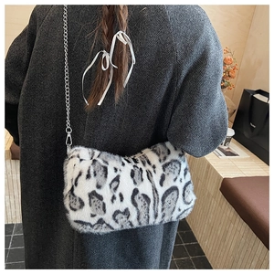 Faux fur leopard print shoulder bag with silver chain strap worn over a grey wool coat