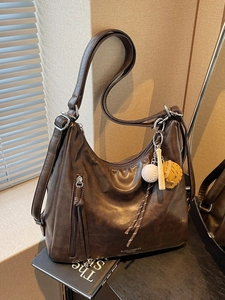 Retro dark brown leather tote bag with creative baseball charm and silver hardware accents