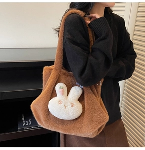 Detail of soft brown plush tote bag with a cute white rabbit charm and pink carrot