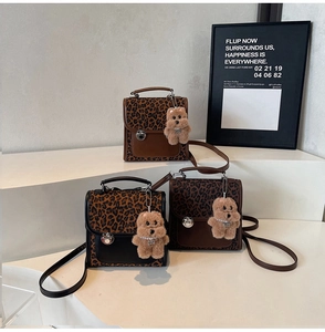 Detailed view of leopard print crossbody bags with plush bear charms and metal twist locks