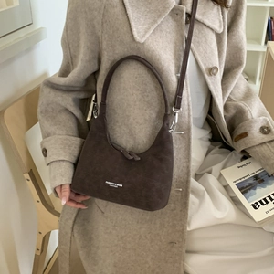 Detail of vintage chocolate brown leather moon bag with adjustable strap and zip closure