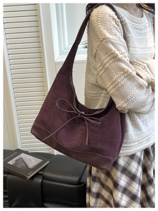 Detail of burgundy vintage tote featuring suede texture and decorative bow on the side