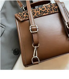 Close-up of leopard print flap detail and adjustable metal hardware on a brown backpack