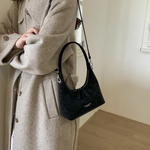 Detail of black matte suede dumpling bag with Fashion & Bags Leather text