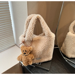 Detail of beige faux fur tote bag with cute brown bear charm and soft fuzzy texture