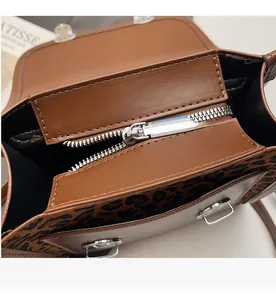 Detail view of smooth metal zipper and leopard print lining on the leather bag