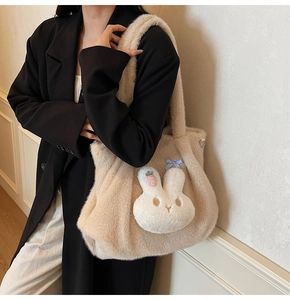 Detail of soft plush tote bag with white bunny patch and plaid bow decoration