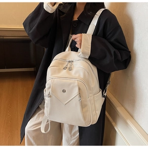 Detail of cream faux leather backpack with pebble texture and V-shaped zip pocket design