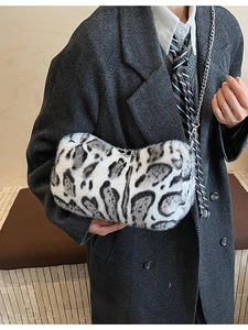 Faux fur leopard print shoulder bag with silver chain strap worn with a grey suit