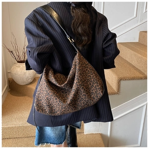 Lifestyle shot of large leopard print hobo bag with adjustable black leather strap
