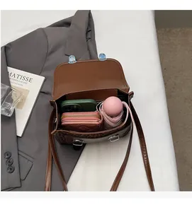 Interior view of vintage brown crossbody bag showing storage for phone and umbrella