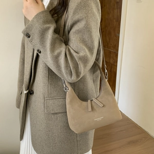 Detail of matte khaki croissant bag with leather texture and white logo print