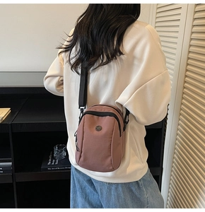 Rear view of a model wearing the mini mauve nylon crossbody bag with adjustable strap