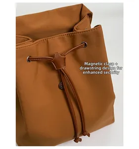 Detail of magnetic buckle and drawstring closure on brown fashion backpack