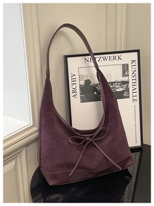 Close-up of purple suede Hobo shoulder bag featuring a decorative ribbon bow accent