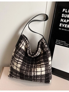 Fashionable black and white checkerboard tweed tote bag with a leather shoulder strap