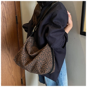 Close-up of leopard print tote bag featuring a gold buckle and adjustable strap
