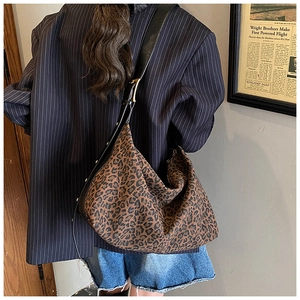 Detail of leopard print tote bag with silver studs on wide black leather shoulder strap