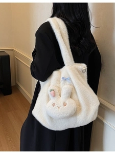 White fuzzy tote bag with cute 3D bunny head and carrot charm shown on shoulder