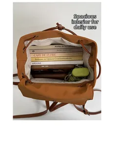 Top view of open caramel backpack showing large interior space with books and umbrella
