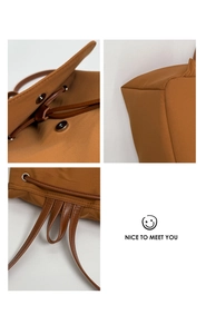 Close-up of caramel nylon backpack featuring magnetic buckle and leather drawstring details
