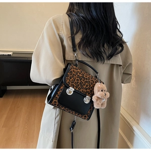Détail du sac à rabat léopard avec fermoirs métalliques et breloque ours en peluche