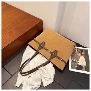 Detail of vintage tote bag with suede texture, brown leather strap and gold hardware